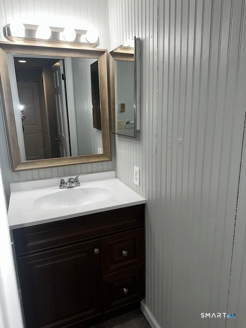 7 Padanaram Road, Unit J232 Danbury, CT 06811 - Photo 19 of 26 a bathroom with a sink a mirror and vanity