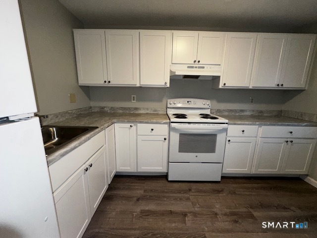 7 Padanaram Road, Unit J232 Danbury, CT 06811 - Photo 5 of 26 a kitchen with granite countertop white cabinets and white appliances