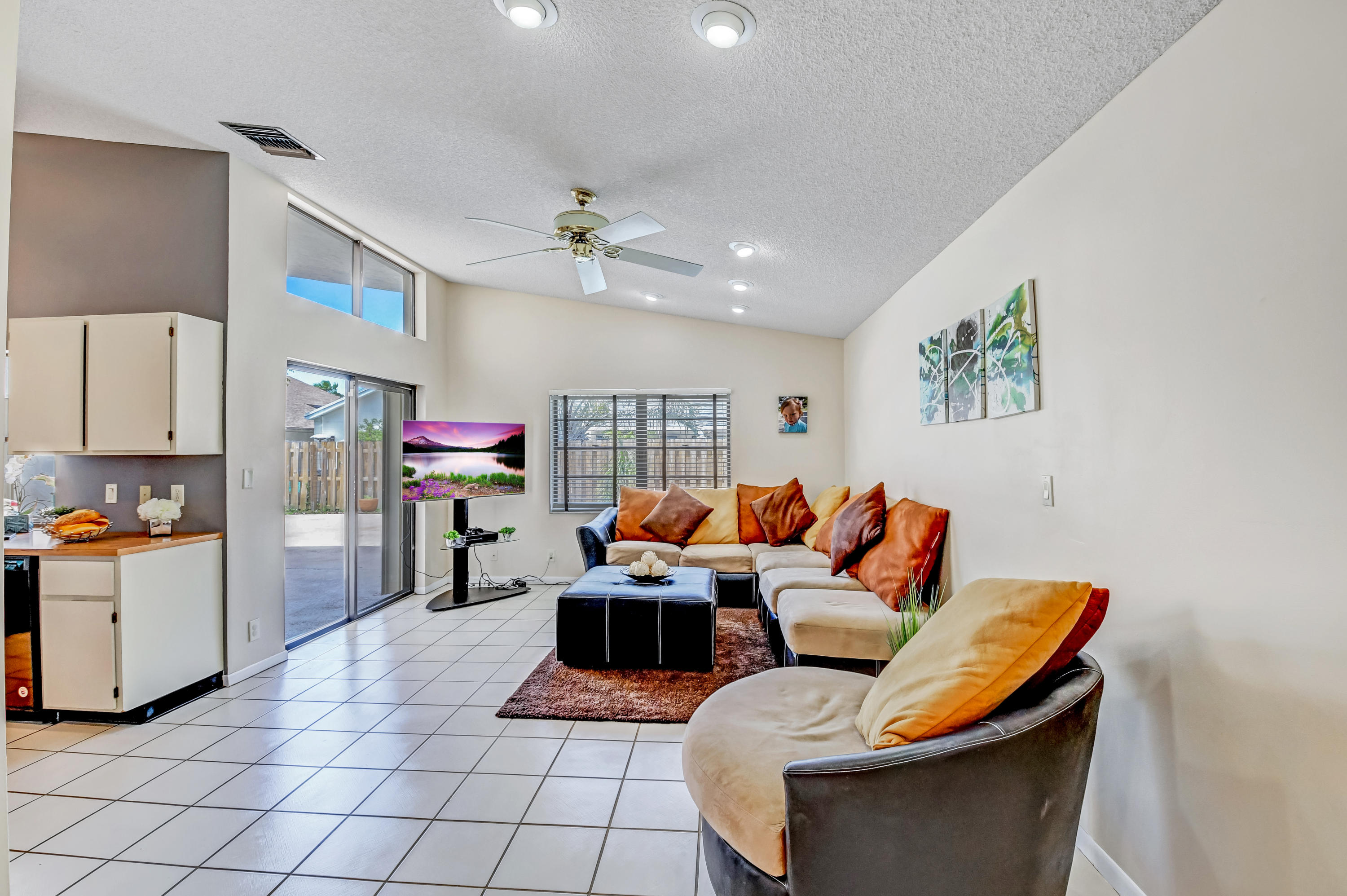 21080 Windemere Lane Boca Raton, FL 33428 - Photo 23 of 97 a living room with furniture a flat screen tv and kitchen view