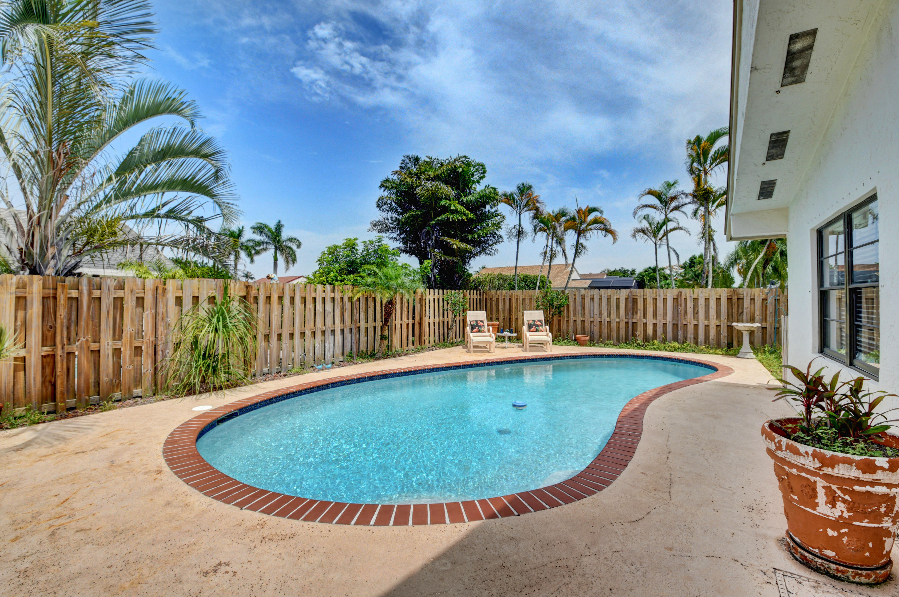 21080 Windemere Lane Boca Raton, FL 33428 - Photo 50 of 97 a view of a swimming pool with a lounge chair