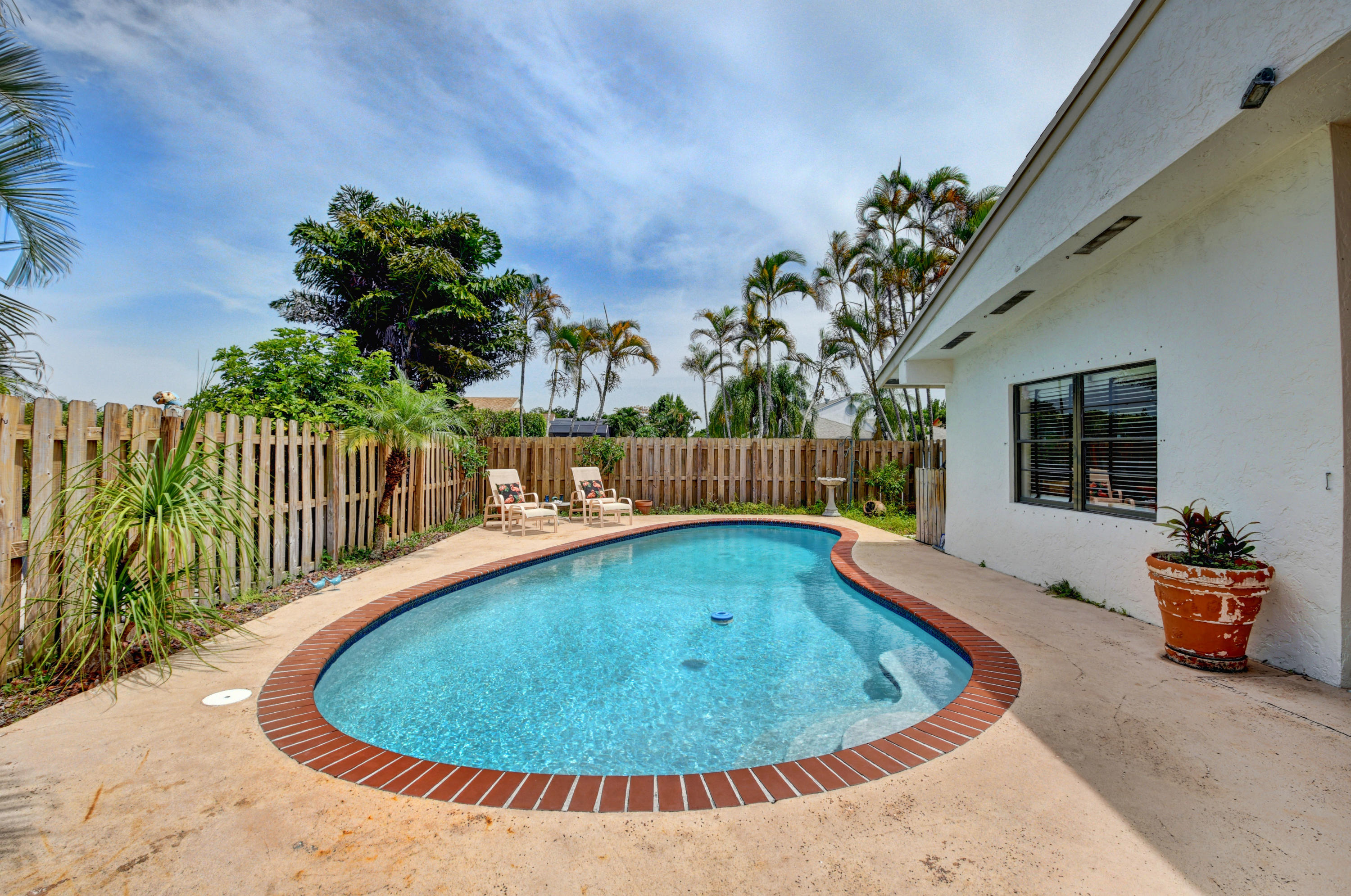 21080 Windemere Lane Boca Raton, FL 33428 - Photo 51 of 97 a view of a swimming pool with a lounge chairs
