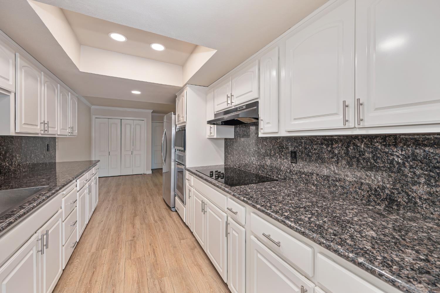 6986 Carreta Lane Rancho Murieta, CA 95683 - Photo 12 of 47 a kitchen with granite countertop a sink and cabinets