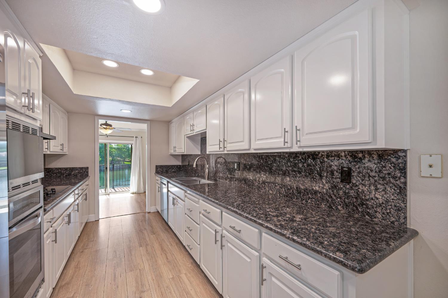 6986 Carreta Lane Rancho Murieta, CA 95683 - Photo 14 of 47 a kitchen with granite countertop a sink a counter space stainless steel appliances and cabinets