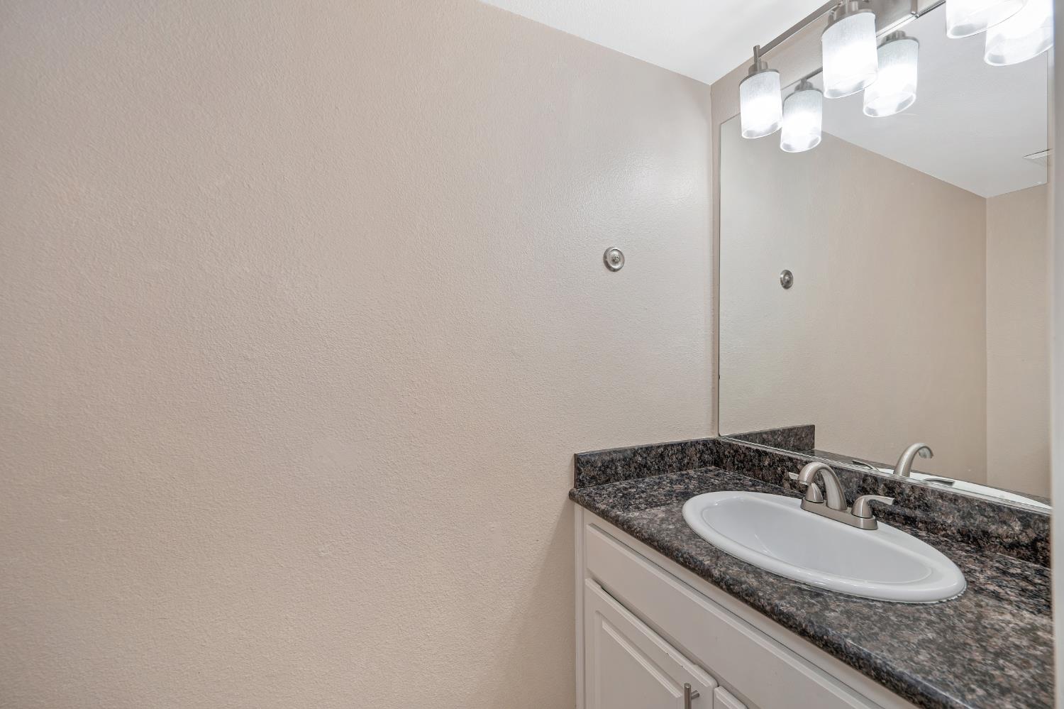 6986 Carreta Lane Rancho Murieta, CA 95683 - Photo 21 of 47 a bathroom with a granite countertop sink and a mirror