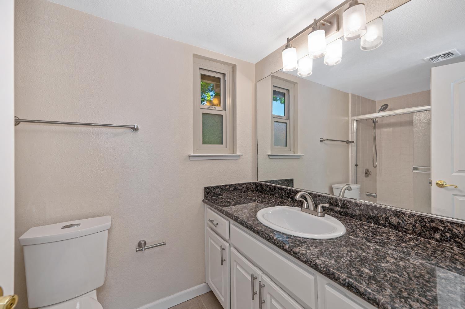 6986 Carreta Lane Rancho Murieta, CA 95683 - Photo 27 of 47 a bathroom with a granite countertop sink a mirror and a shower