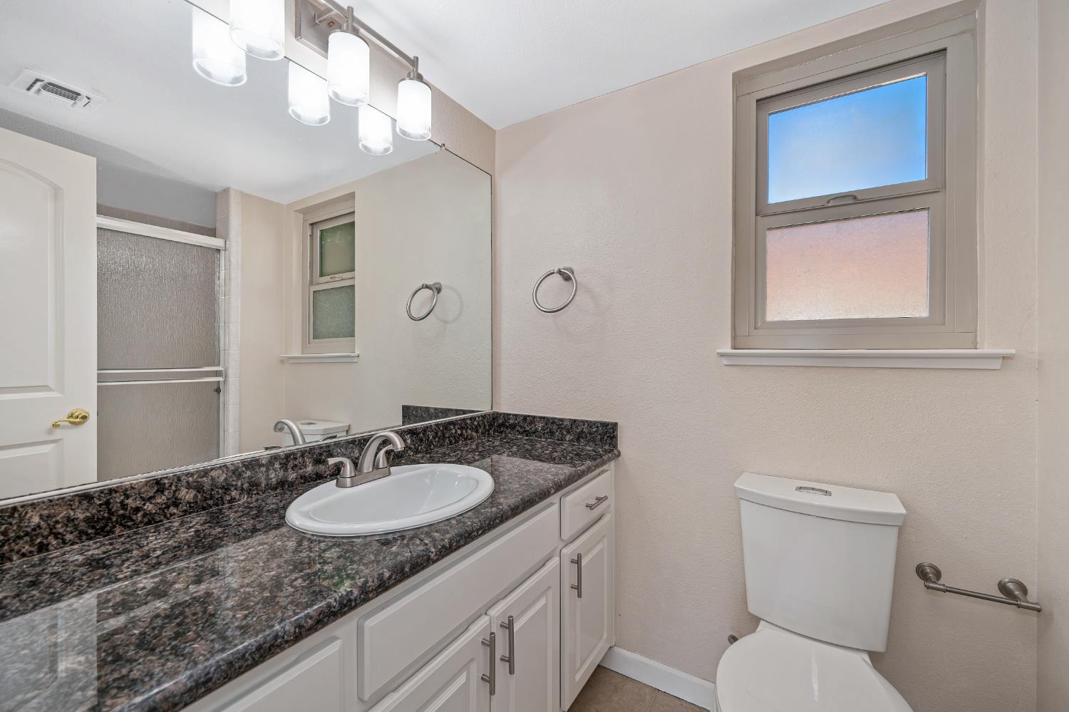 6986 Carreta Lane Rancho Murieta, CA 95683 - Photo 30 of 47 a bathroom with a granite countertop sink toilet and a mirror