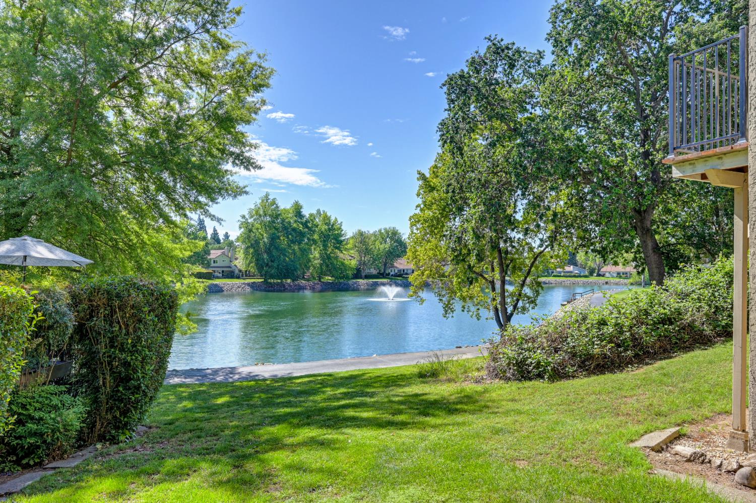 6986 Carreta Lane Rancho Murieta, CA 95683 - Photo 33 of 47 a view of a lake with a house in the background