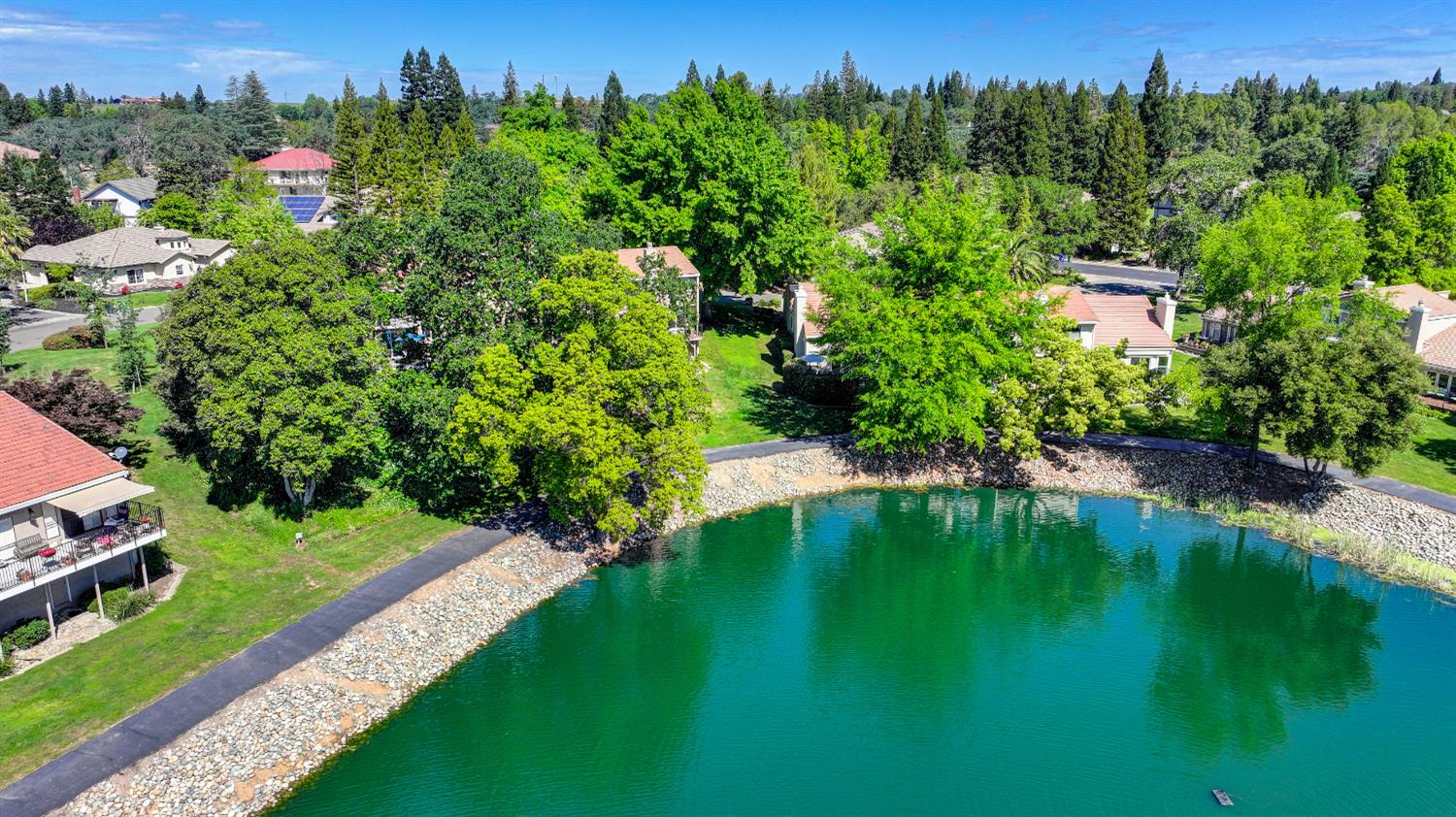 6986 Carreta Lane Rancho Murieta, CA 95683 - Photo 40 of 47 a view of a lake with a building in the background