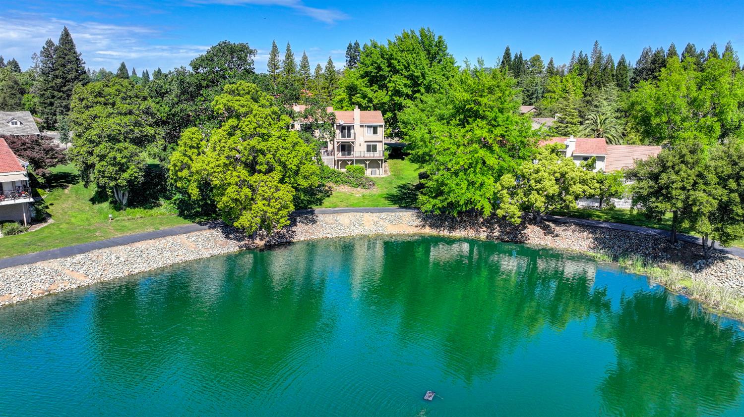 6986 Carreta Lane Rancho Murieta, CA 95683 - Photo 43 of 47 a view of a lake with a building in the background