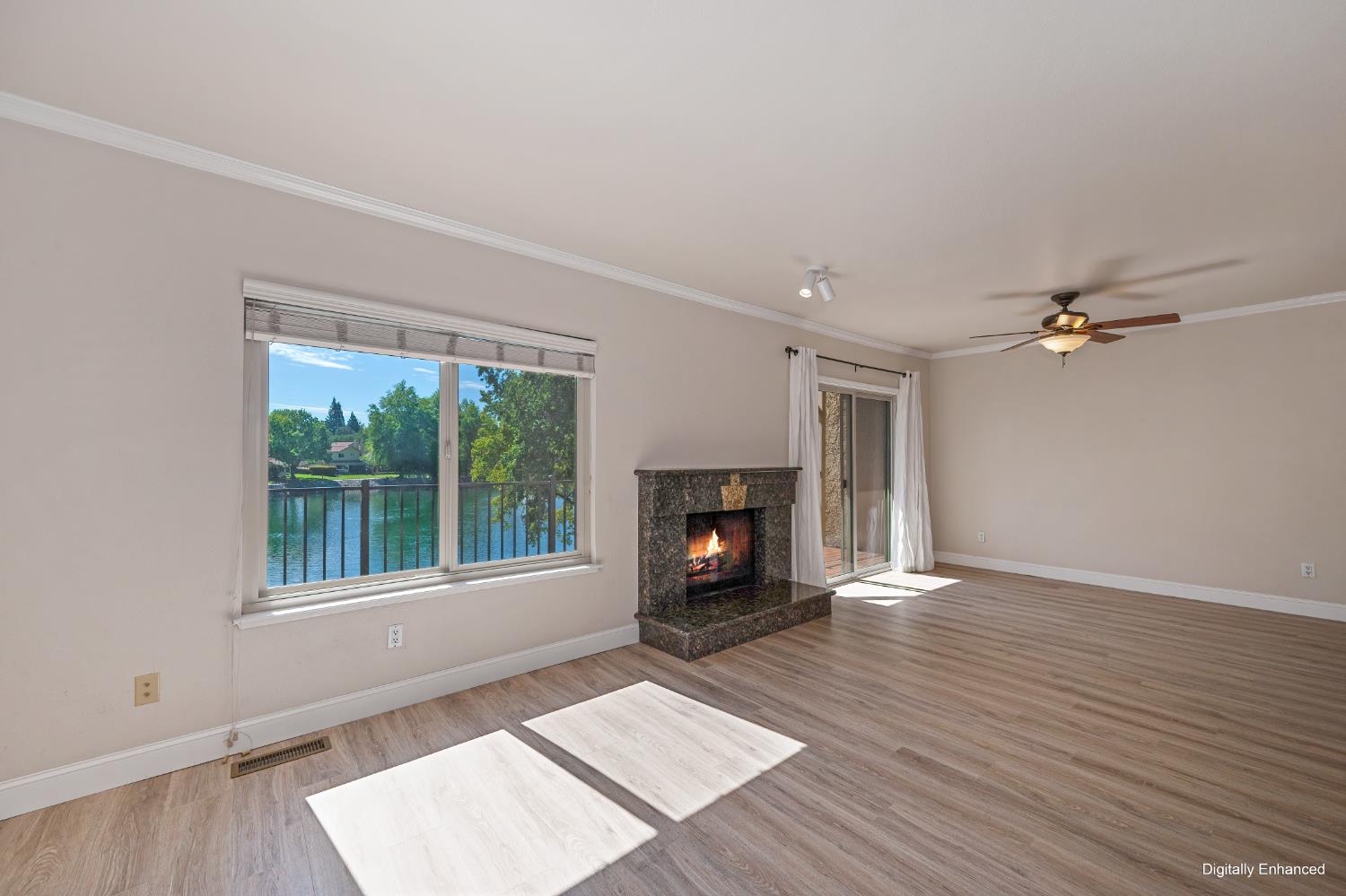 6986 Carreta Lane Rancho Murieta, CA 95683 - Photo 8 of 47 an empty room with windows fireplace and wooden floor
