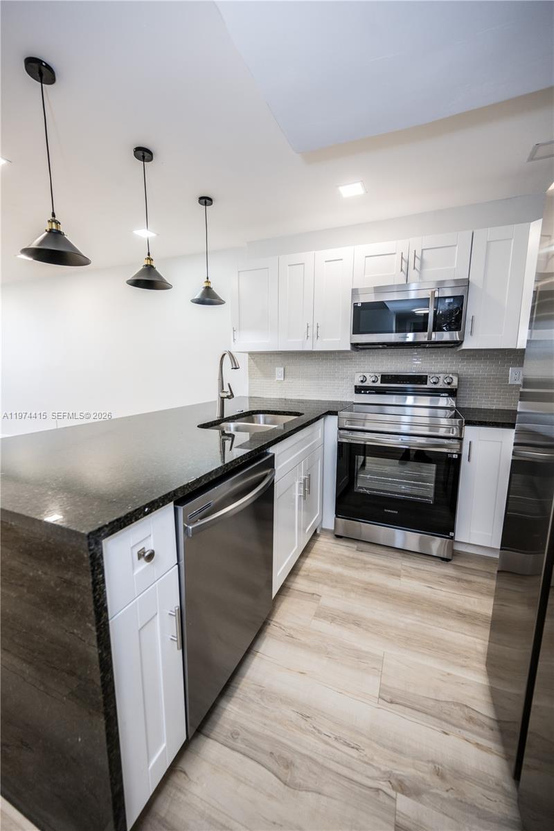 755 Dotterel Road, Unit 1301 Delray Beach, FL 33444 - Photo 4 of 15 a kitchen with stainless steel appliances and white cabinets