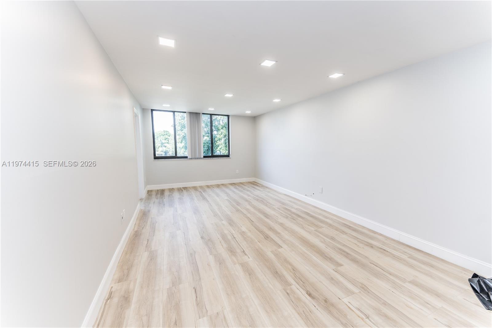 755 Dotterel Road, Unit 1301 Delray Beach, FL 33444 - Photo 6 of 15 an empty room with wooden floor and windows