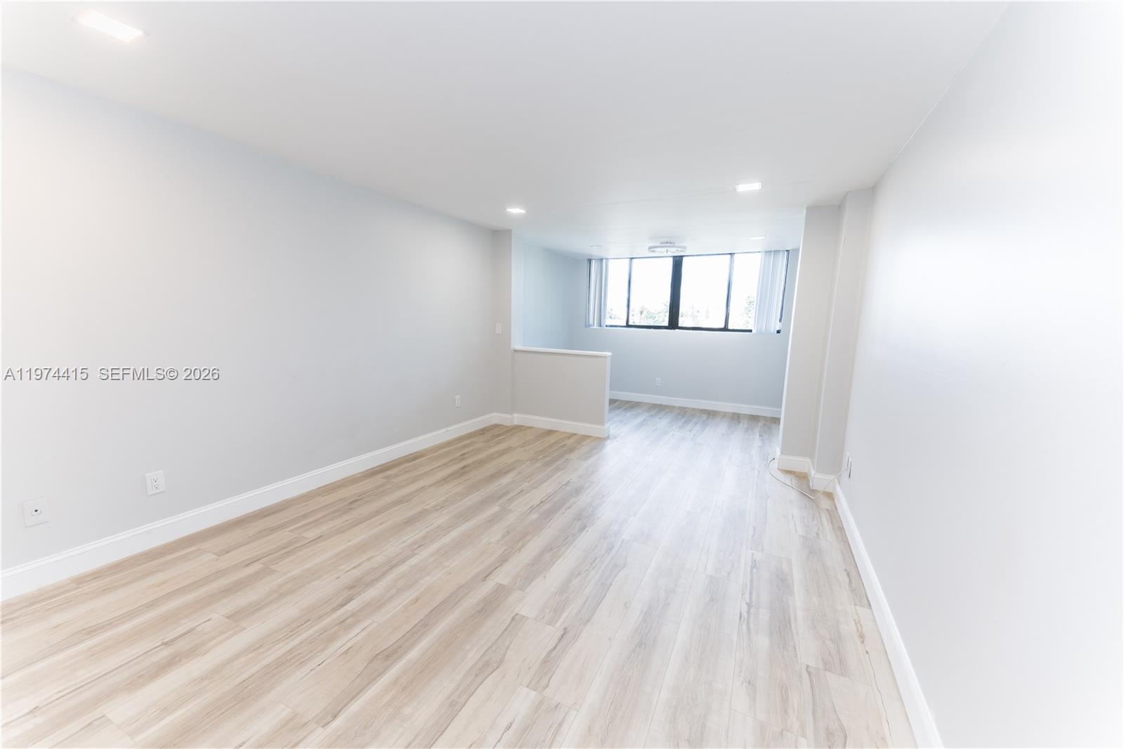 755 Dotterel Road, Unit 1301 Delray Beach, FL 33444 - Photo 7 of 15 an empty room with wooden floor and windows