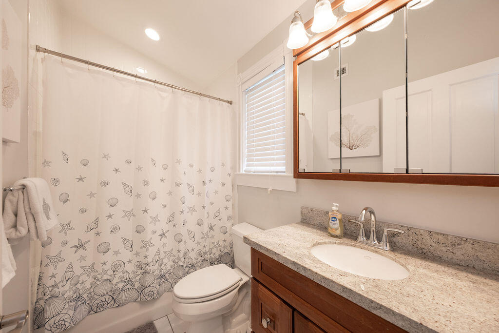 1320 South Street Key West, FL 33040 - Photo 26 of 36 a bathroom with a granite countertop sink a toilet and a mirror