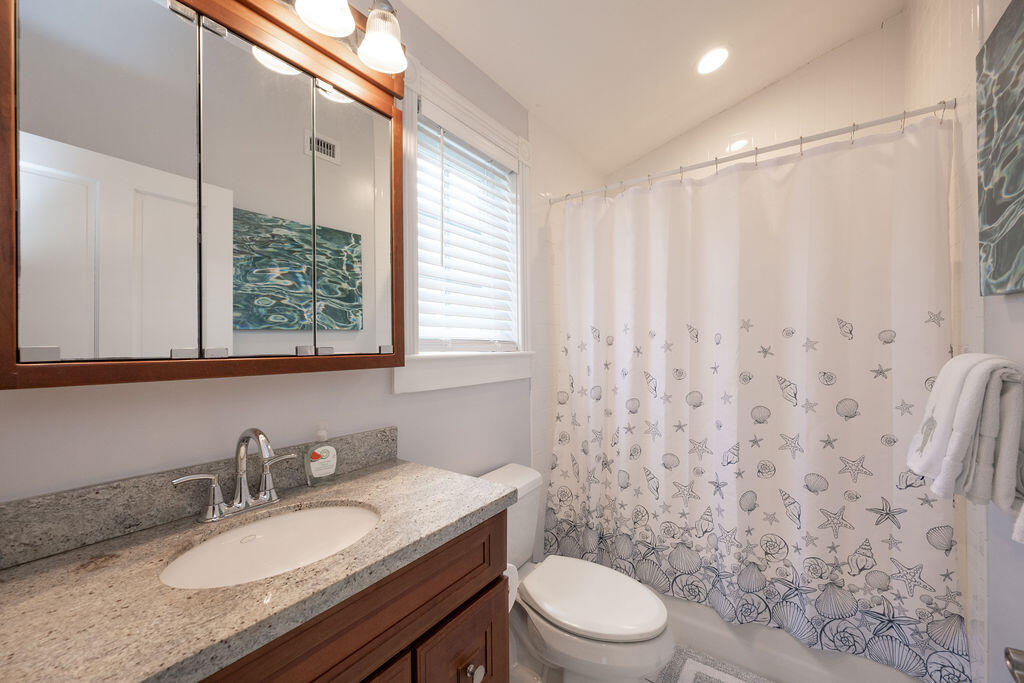 1320 South Street Key West, FL 33040 - Photo 30 of 36 a bathroom with a granite countertop sink toilet a mirror and a shower