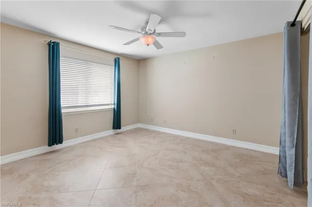 an empty room with closet and a chandelier fan