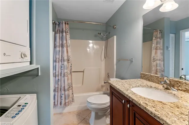 a bathroom with a granite countertop sink a toilet and shower