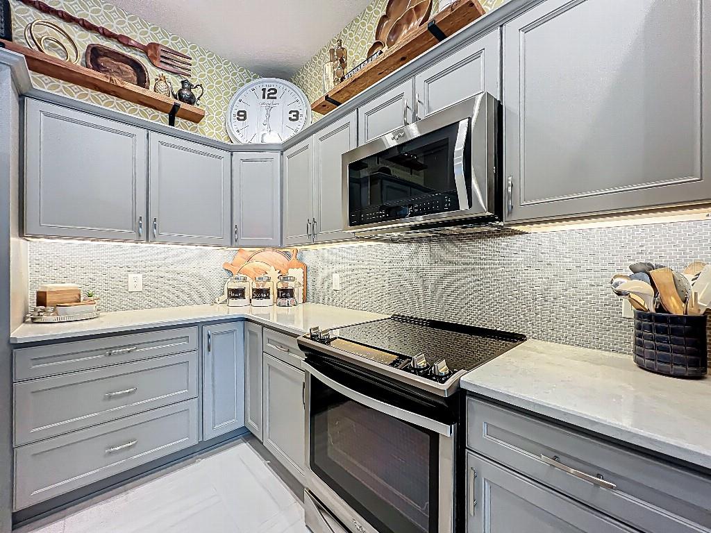3191 Warbler Loop The Villages, FL 32163 - Photo 13 of 42 a kitchen with stainless steel appliances granite countertop a sink and a stove