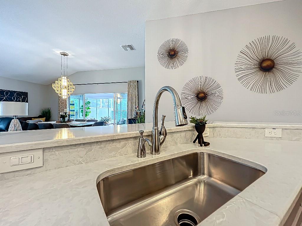 3191 Warbler Loop The Villages, FL 32163 - Photo 14 of 42 a kitchen with a faucet a sink and chandelier
