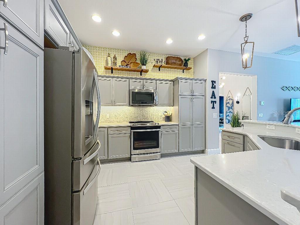 3191 Warbler Loop The Villages, FL 32163 - Photo 15 of 42 a kitchen with stainless steel appliances a refrigerator sink and stove