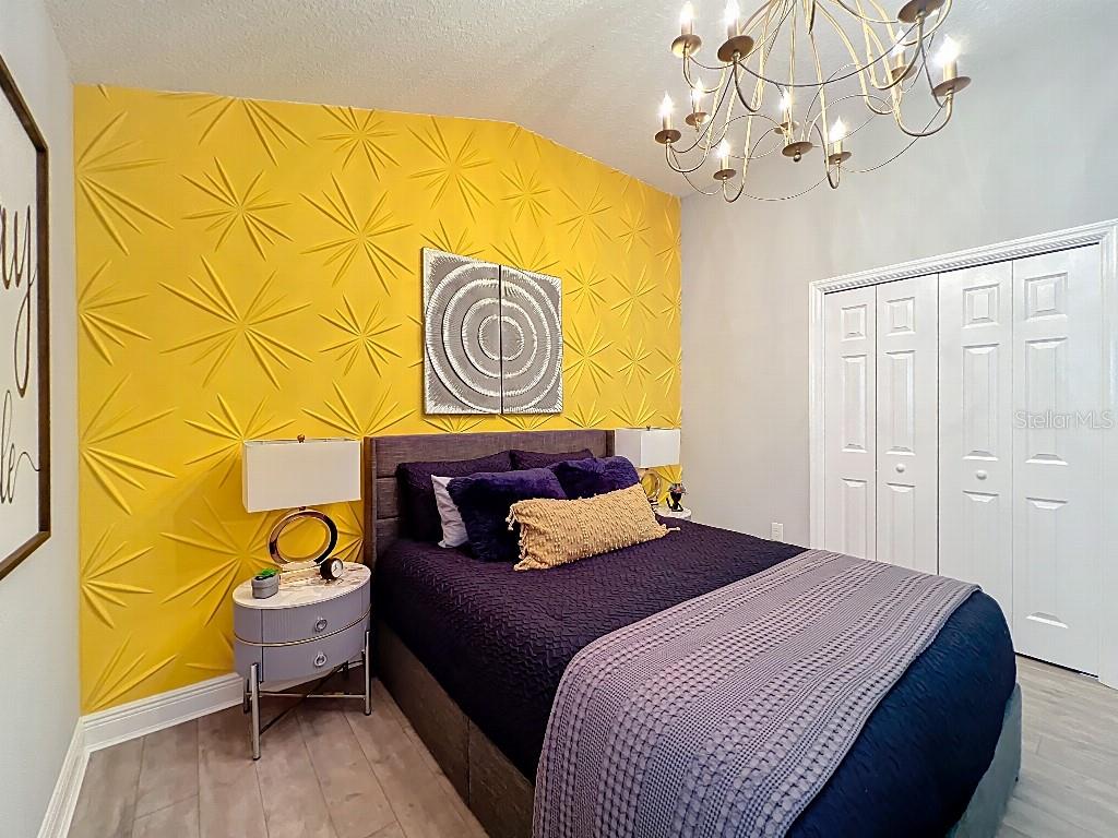 3191 Warbler Loop The Villages, FL 32163 - Photo 27 of 42 a bedroom with a bed and painting on the wall