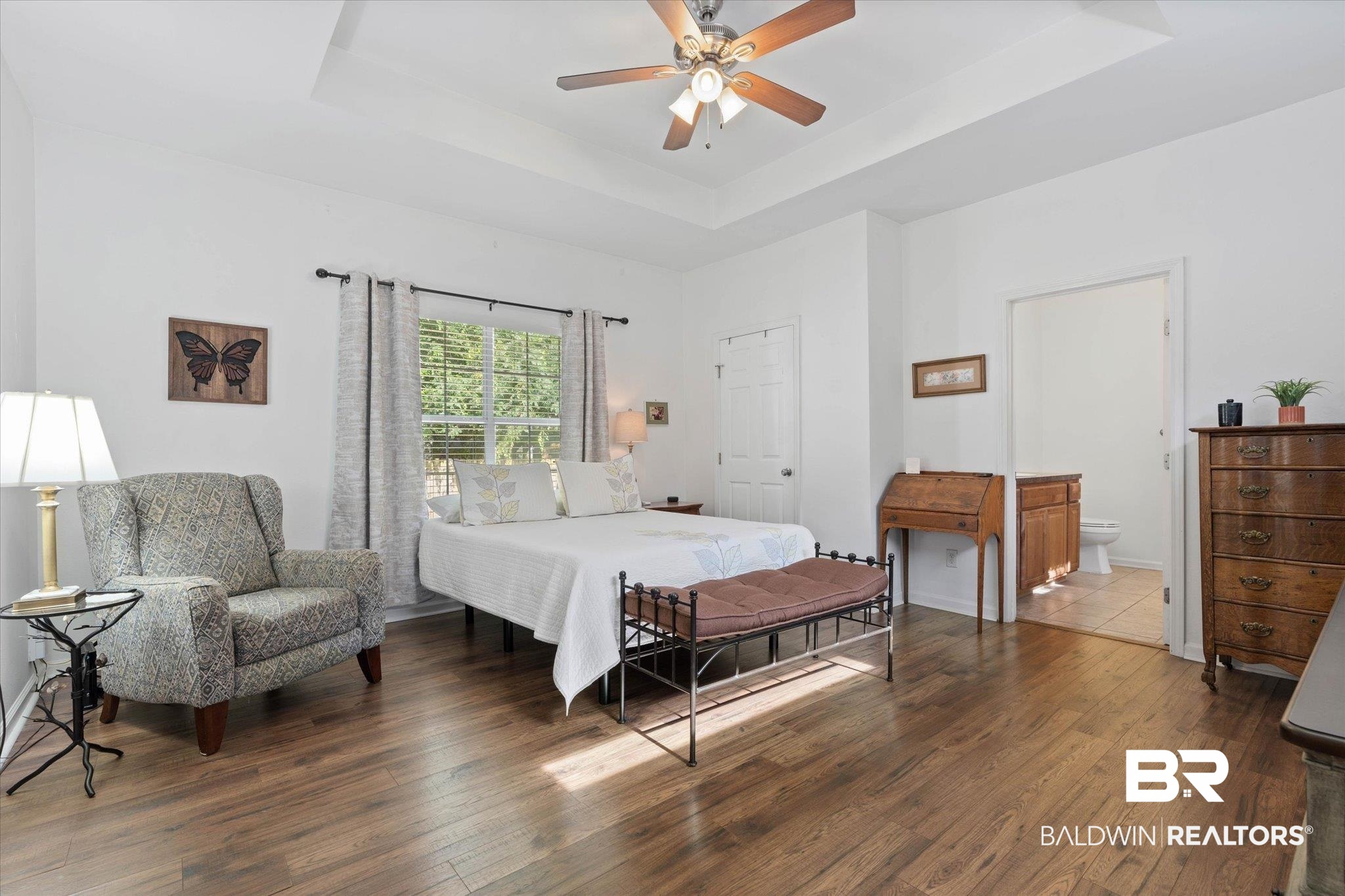 1910 Hunter Avenue Mobile, AL 36606 - Photo 10 of 21 Bedroom featuring a tray ceiling, wood finished floors, ensuite bathroom, and ceiling fan
