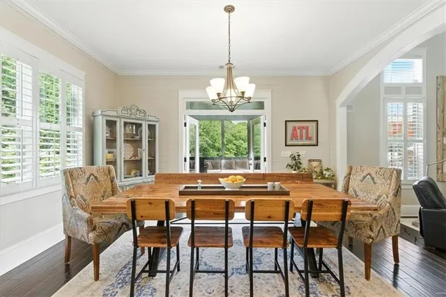 a kitchen with stainless steel appliances a dining table chairs stove refrigerator and cabinets