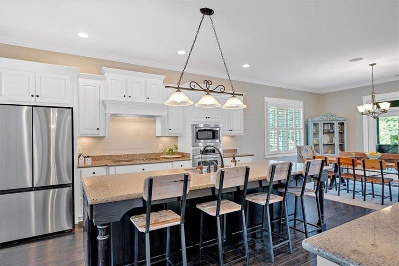 1021 Avery Road Canton, GA 30115 - Photo 16 of 70 a kitchen with stainless steel appliances a dining table chairs stove refrigerator and cabinets