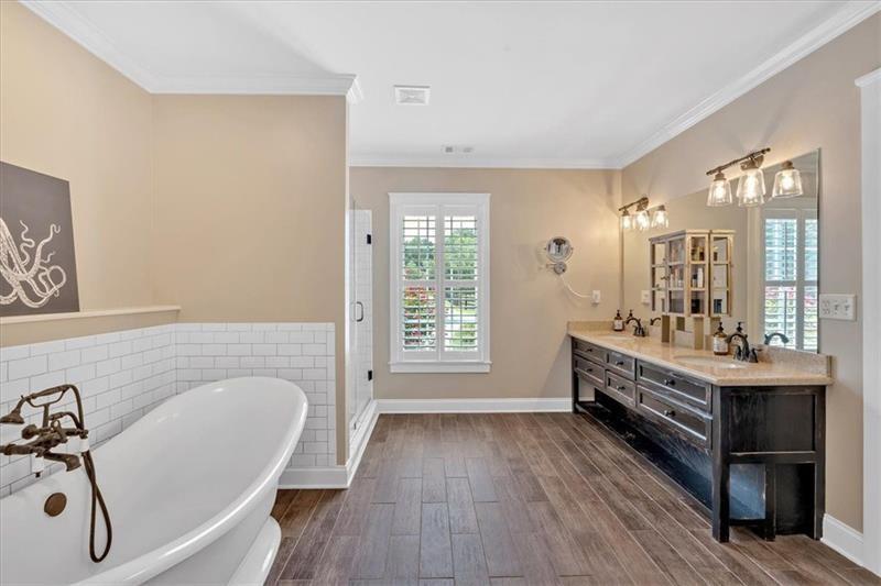1021 Avery Road Canton, GA 30115 - Photo 27 of 70 a bathroom with a double vanity sink a mirror and a bathtub