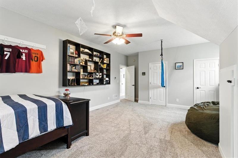 1021 Avery Road Canton, GA 30115 - Photo 34 of 70 a spacious bedroom with a large bed and a chandelier