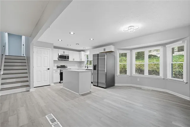 a view of kitchen with stainless steel appliances refrigerator oven and cabinets