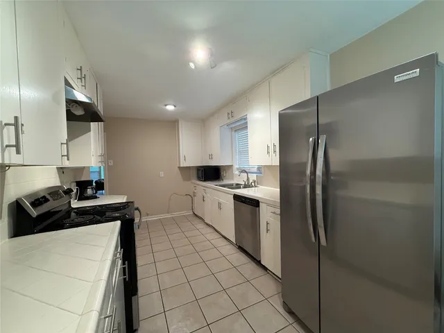 a kitchen with a refrigerator and a sink