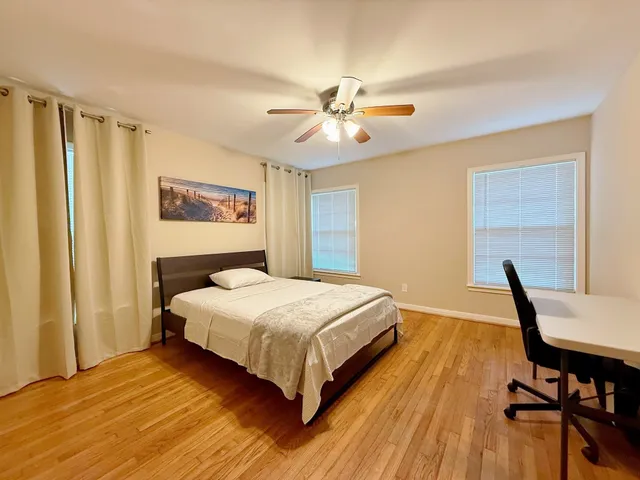 a bedroom with a bed and wooden floor