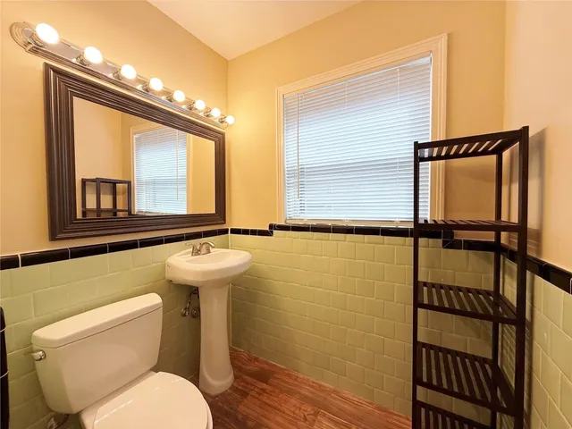 a bathroom with a toilet sink and a mirror