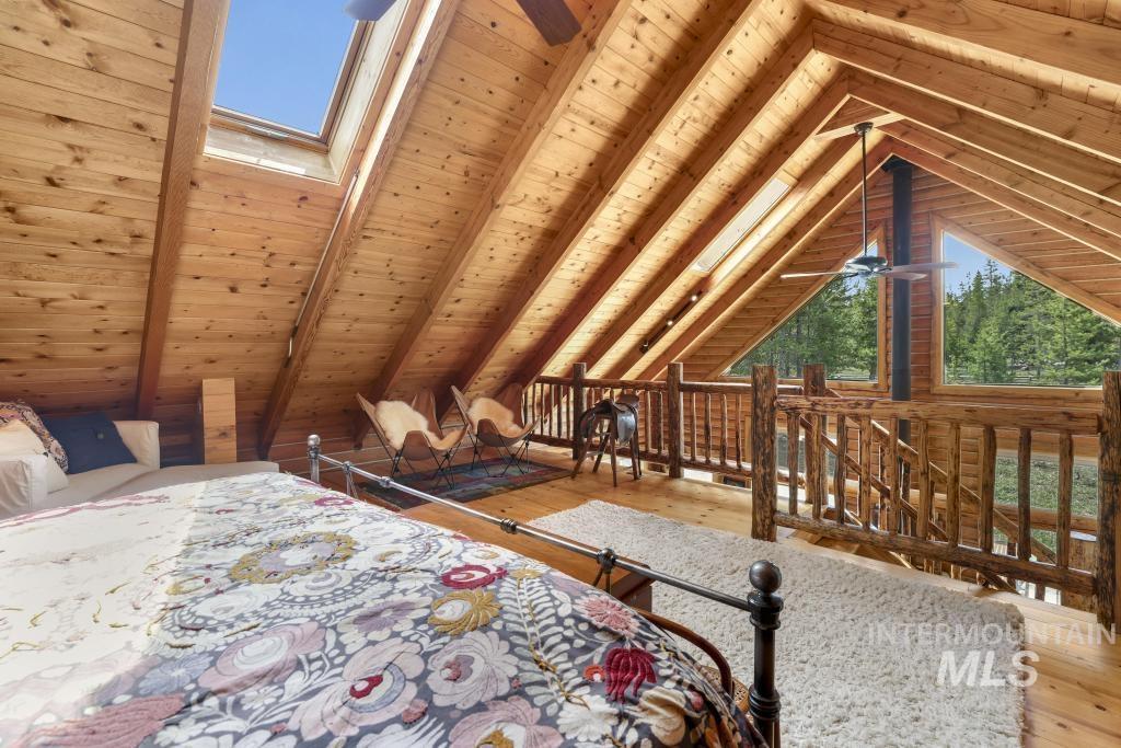 65 Goat Creek Way Stanley, ID 83278 - Photo 19 of 32 Vaulted wood-paneled ceiling with exposed beams, featuring a skylight and a ceiling fan