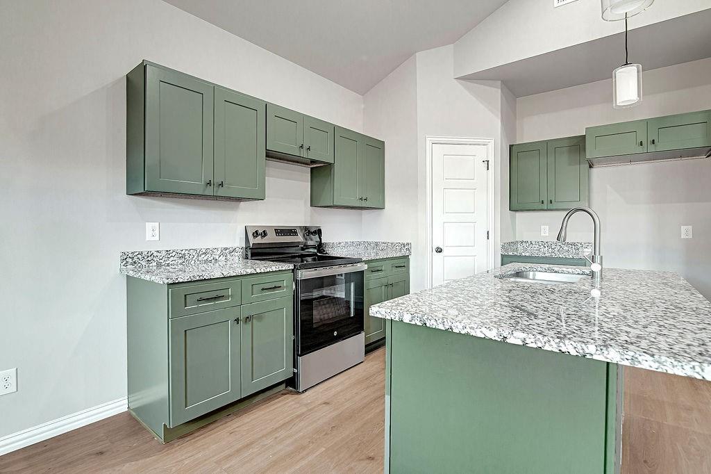 2729 Finley Street Fort Worth, TX 76111 - Photo 12 of 30 a kitchen with stainless steel appliances granite countertop a sink stove and cabinets