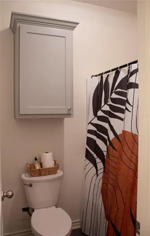 a bathroom with a toilet and a mirror