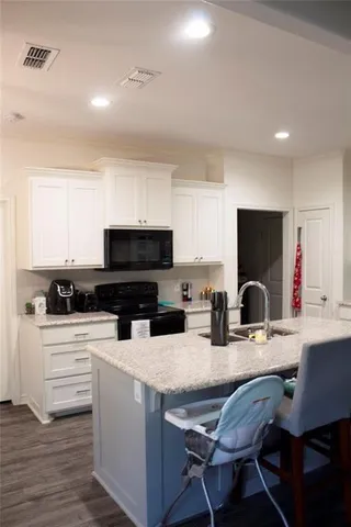 a kitchen with stainless steel appliances a stove a sink a microwave a refrigerator and cabinets