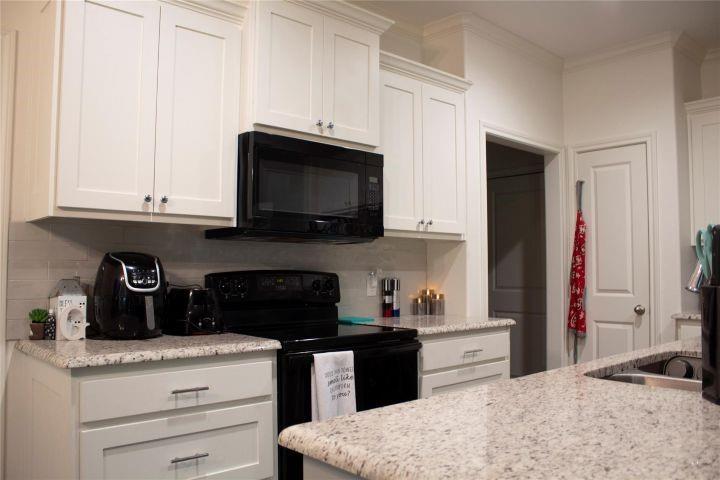 604 Head Street Palestine, TX 75801 - Photo 7 of 21 a kitchen with granite countertop white cabinets and black appliances