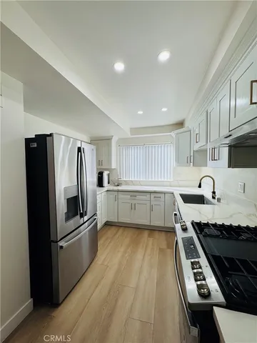 a kitchen with granite countertop a refrigerator and a stove top oven