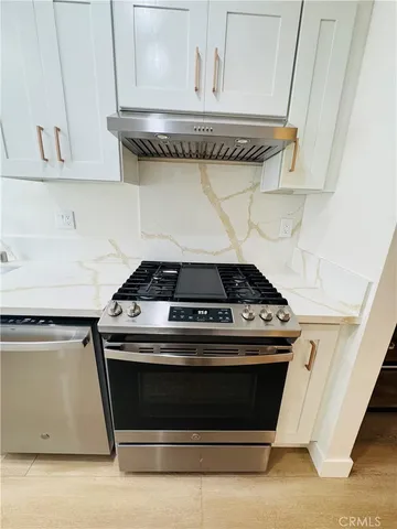a stove top oven sitting inside of a kitchen