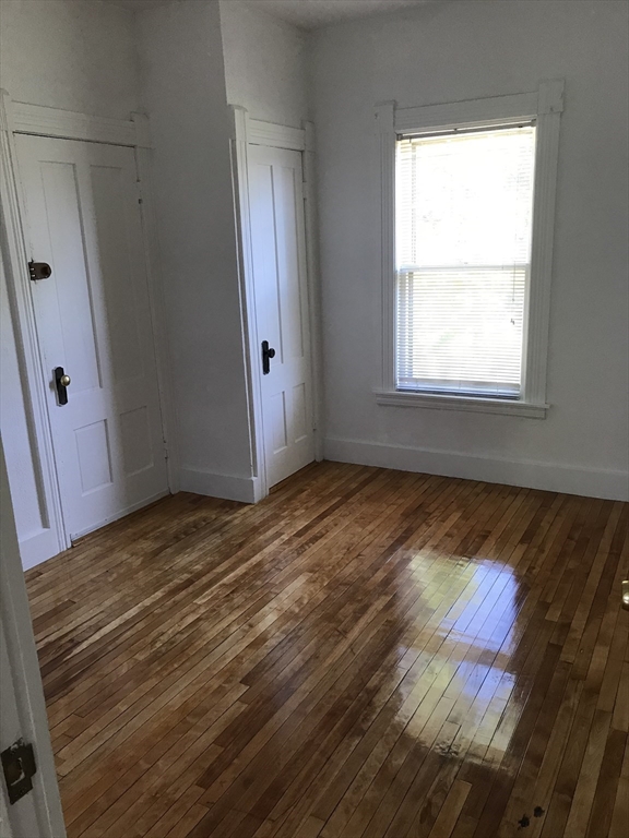 123 Mayfield Street, Unit 2 Worcester, MA 01602 - Photo 12 of 16 an empty room with wooden floor and windows