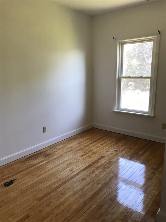 123 Mayfield Street, Unit 2 Worcester, MA 01602 - Photo 13 of 16 an empty room with wooden floor and windows