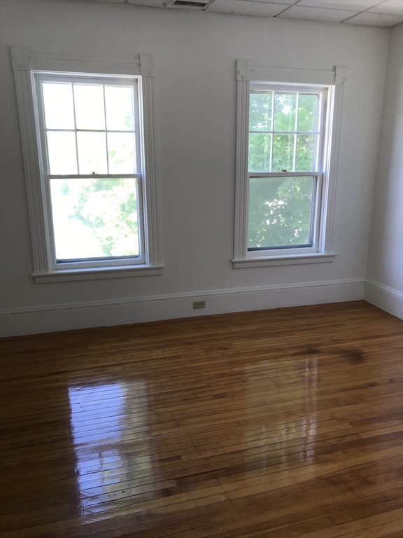 123 Mayfield Street, Unit 2 Worcester, MA 01602 - Photo 9 of 16 a view of an empty room with wooden floor and a window