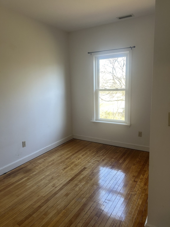 123 Mayfield Street, Unit 2 Worcester, MA 01602 - Photo 10 of 16 an empty room with wooden floor and windows