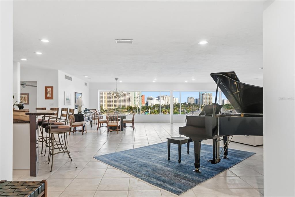 660 Golden Gate Point, Unit 61 Sarasota, FL 34236 - Photo 15 of 44 a living room with couches a coffee table and a piano table with wooden floor
