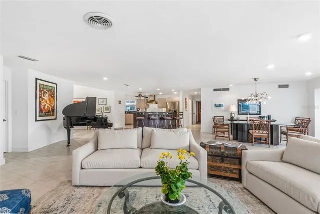 a living room with furniture kitchen view and a chandelier