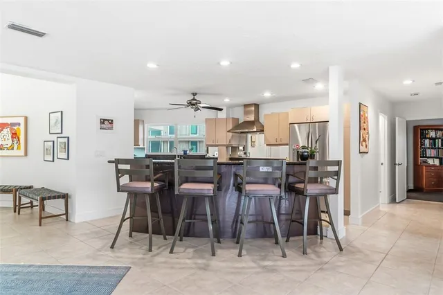 a kitchen with stainless steel appliances kitchen island granite countertop a table chairs in it and wooden floors