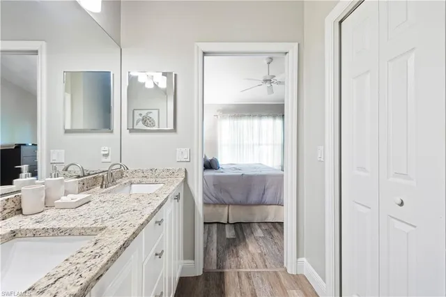 a en suite bathroom with a granite countertop sink and a mirror