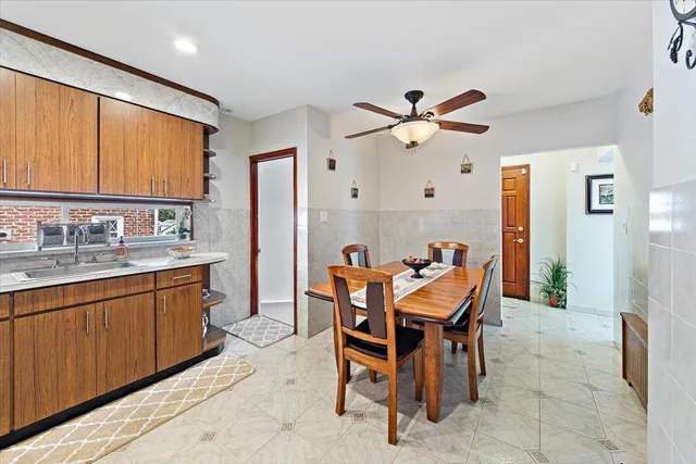 a dining room filled a chandelier and a view of kitchen